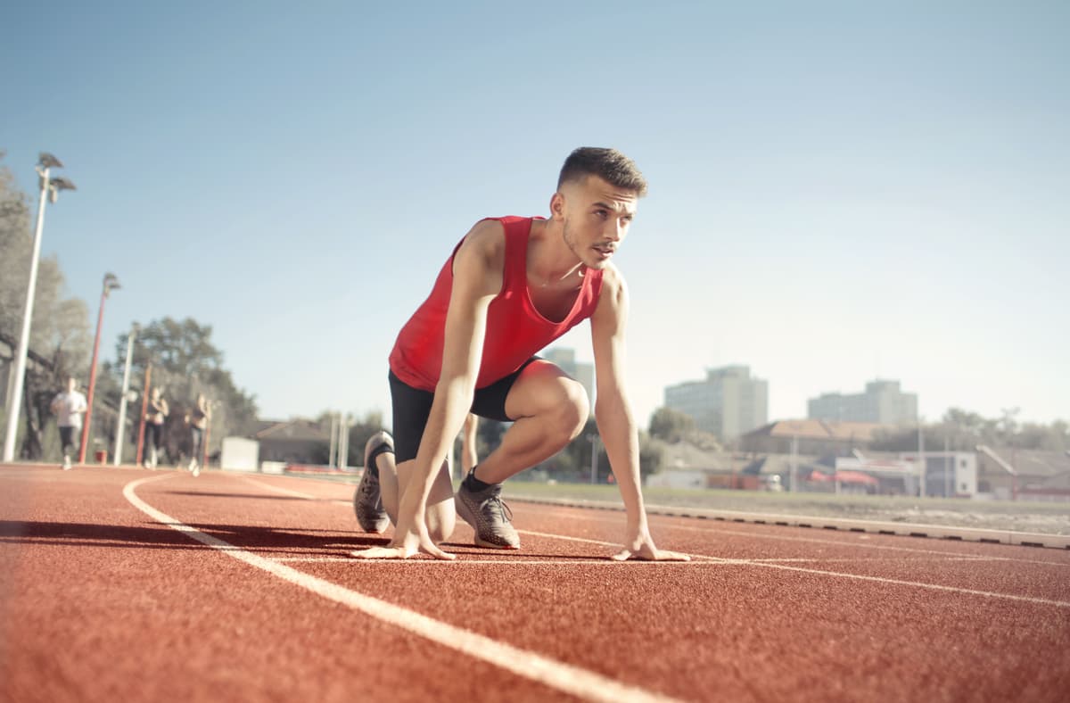 A sprinter in the starting position on a running track