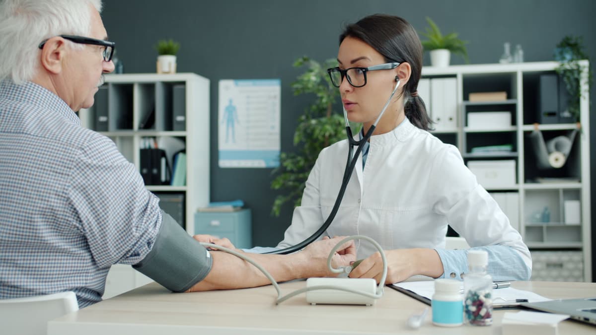 A doctor measuring an older man's blood pressure