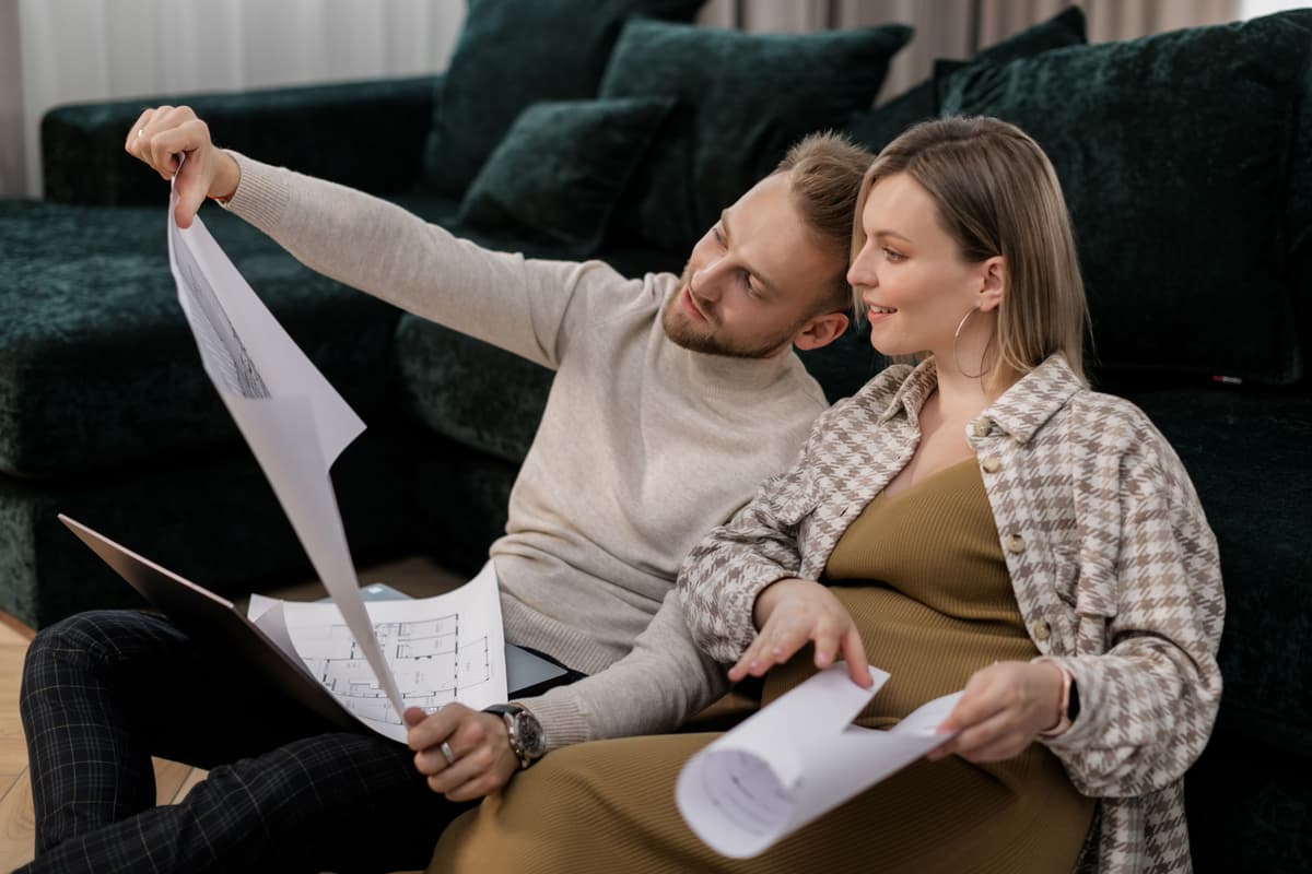 A couple looking through papers together on a sofa