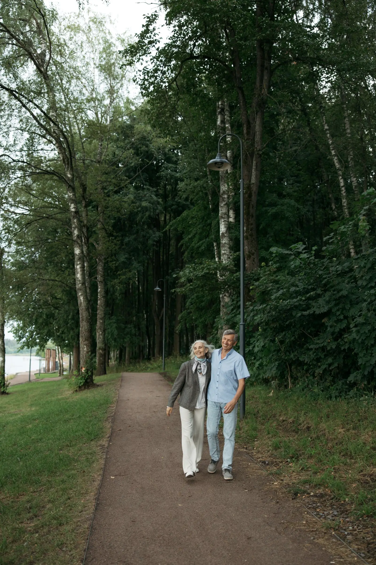 An older couple walking on a forest path